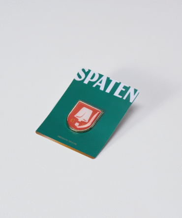 Ilustração pin metálico vermelho com brasão da marca Spaten.